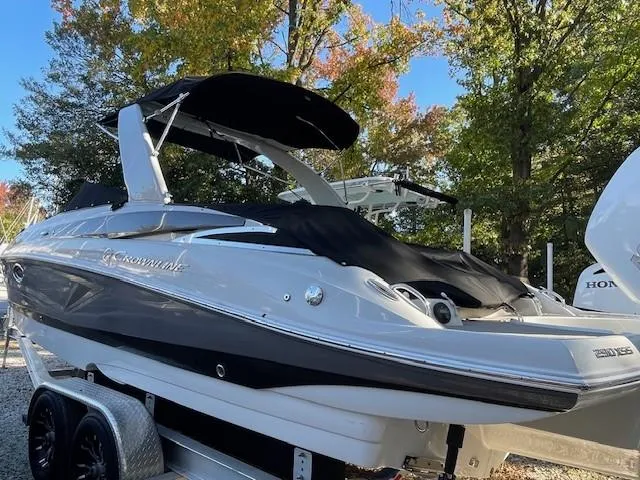 Slide: The Image of 2023 Crownline 290 XSS boat on trailer, surrounded by trees. - 10