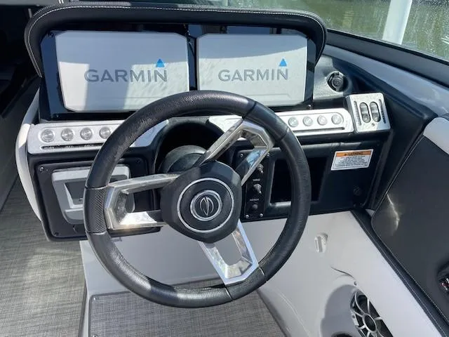 Slide: The Image of 2023 Crownline 290 XSS boat dashboard with Garmin displays and steering wheel. - 25