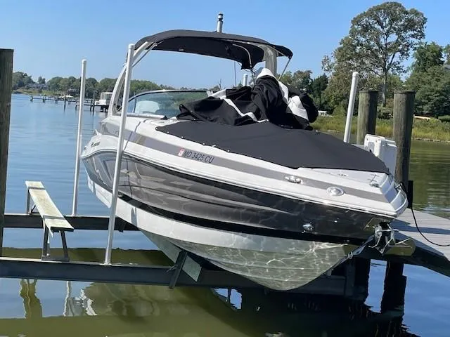 Slide: The Image of 2023 Crownline 290 XSS boat on lift by the water. - 4