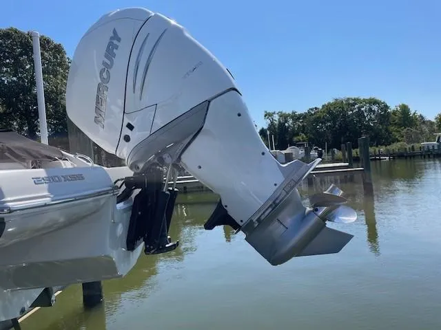 Slide: The Image of 2023 Crownline 290 XSS boat with Mercury outboard motor on a calm lake. - 6