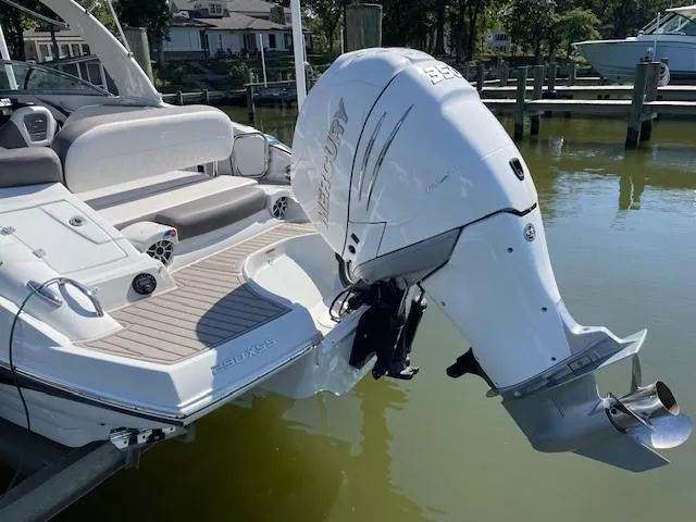 Slide: The Image of 2023 Crownline 290 XSS boat with powerful outboard motor docked in marina. - 7