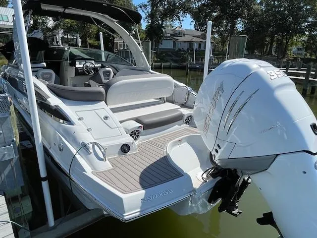 Slide: The Image of 2023 Crownline 290 XSS boat with Mercury engine, docked in a serene marina. - 8