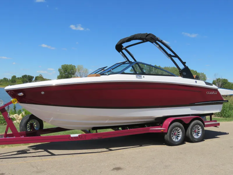 Slide: The Image of 2024 Cobalt R4 boat on trailer, red and white design, sunny day. - 0
