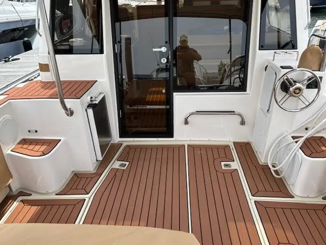 Slide: The Image of 2023 Ranger Tugs R-29 S boat interior with teak flooring and helm station. - 14