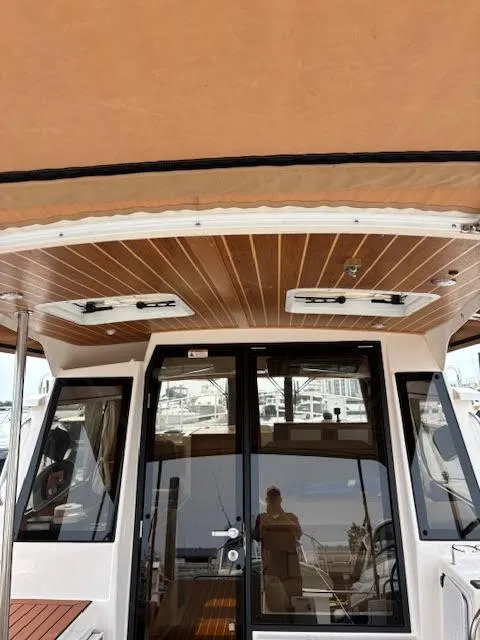 Slide: The Image of 2023 Ranger Tugs R-29 S boat interior with wood ceiling and glass doors. - 17