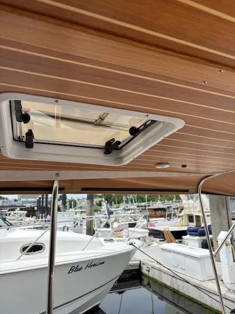 Slide: The Image of 2023 Ranger Tugs R-29 S boat interior with wooden ceiling and hatch, docked at marina. - 18