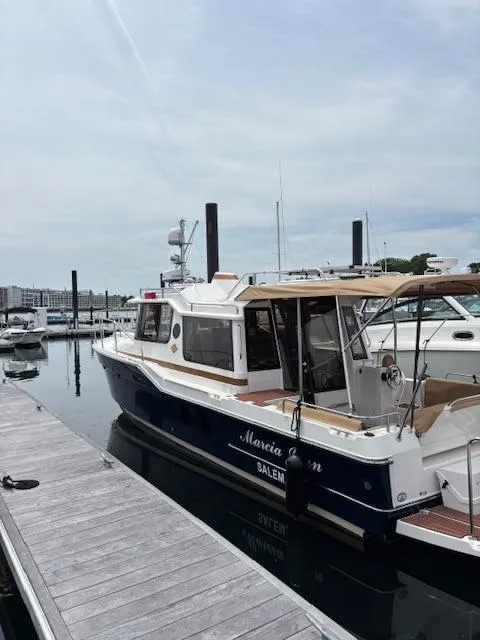 Slide: The Image of 2023 Ranger Tugs R-29 S docked at marina, featuring sleek design and modern amenities. - 2