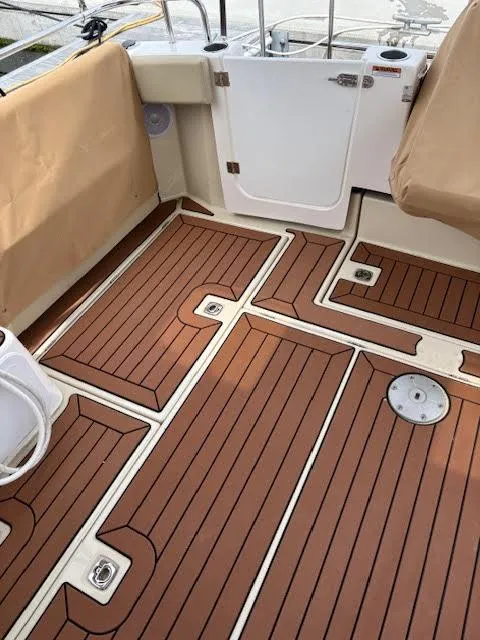 Slide: The Image of 2023 Ranger Tugs R-29 S boat deck with teak-style flooring and beige seating. - 20