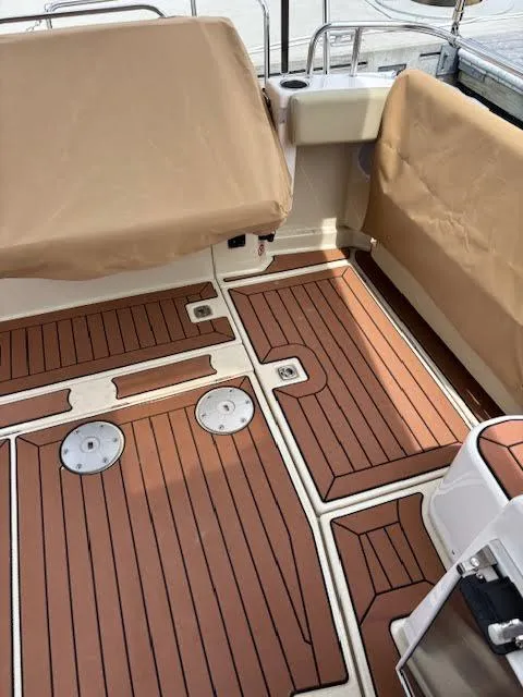 Slide: The Image of 2023 Ranger Tugs R-29 S boat deck with wood finish and beige covers. - 21