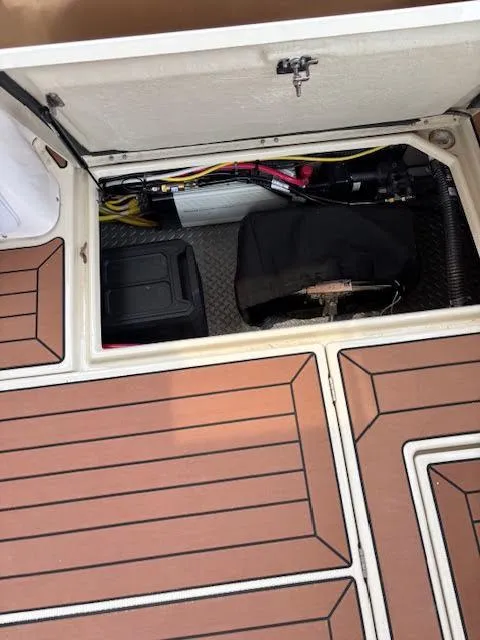Slide: The Image of 2023 Ranger Tugs R-29 S storage compartment with equipment and wooden deck flooring. - 26