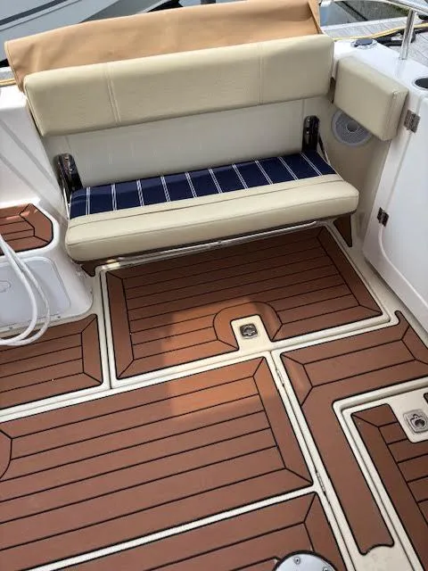 Slide: The Image of 2023 Ranger Tugs R-29 S boat interior with cushioned seating and teak-style flooring. - 27