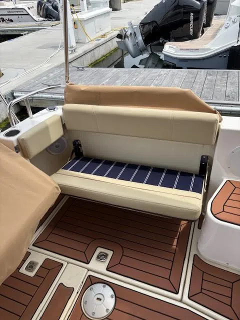 Slide: The Image of 2023 Ranger Tugs R-29 S boat with tan seating and wood-patterned deck. - 28