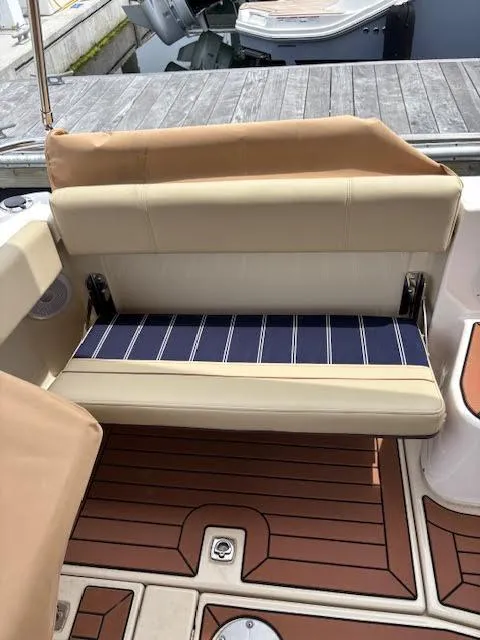 Slide: The Image of 2023 Ranger Tugs R-29 S boat interior with cushioned seating and teak-style flooring. - 29