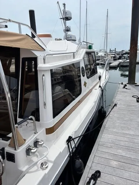 Slide: The Image of 2023 Ranger Tugs R-29 S docked at a marina, showcasing sleek design and modern features. - 3