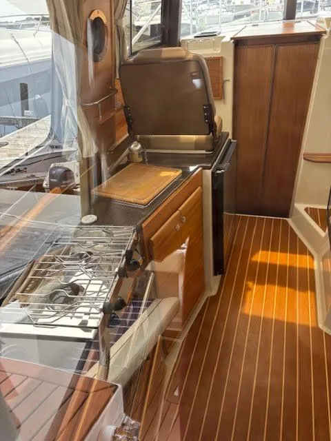 Slide: The Image of 2023 Ranger Tugs R-29 S interior with wooden flooring and compact kitchen area. - 31