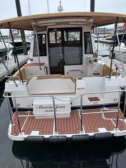 Slide: The Image of 2023 Ranger Tugs R-29 S boat docked, rear view with teak deck and canopy. - 6