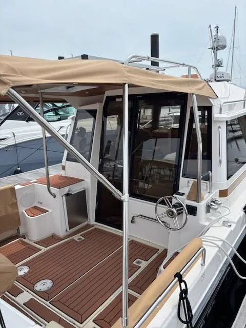 Slide: The Image of 2023 Ranger Tugs R-29 S boat with canopy and wooden deck, docked at marina. - 8