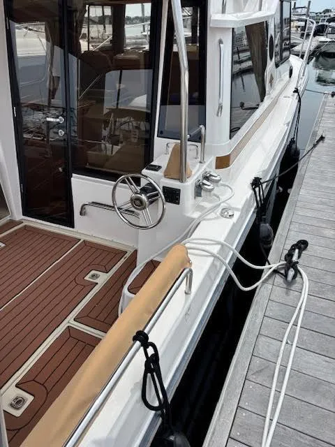 Slide: The Image of 2023 Ranger Tugs R-29 S docked, showcasing elegant deck and steering wheel. - 9