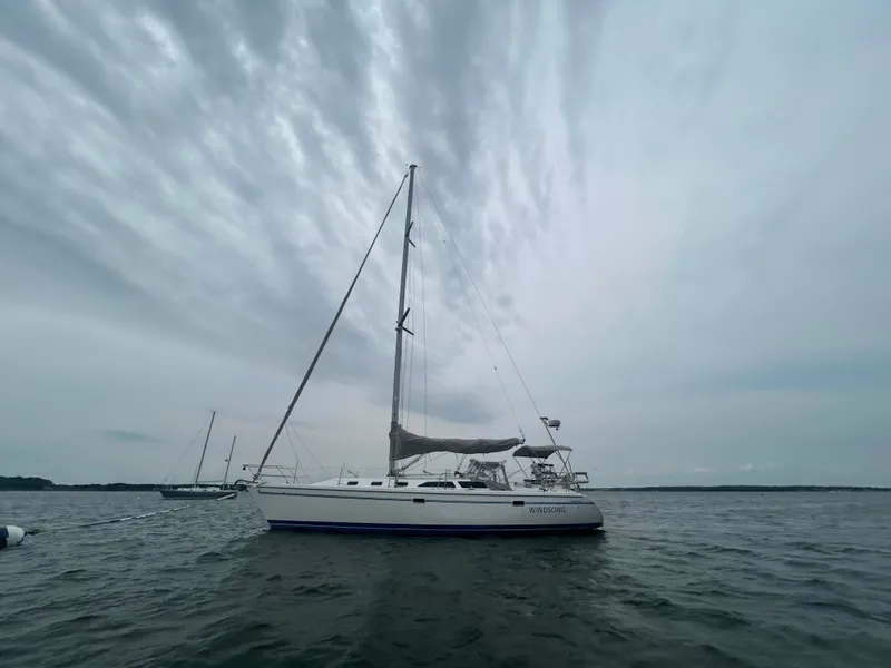 Slide: The Image of 1998 Catalina 42 MkII sailboat on calm waters under cloudy sky. - 0
