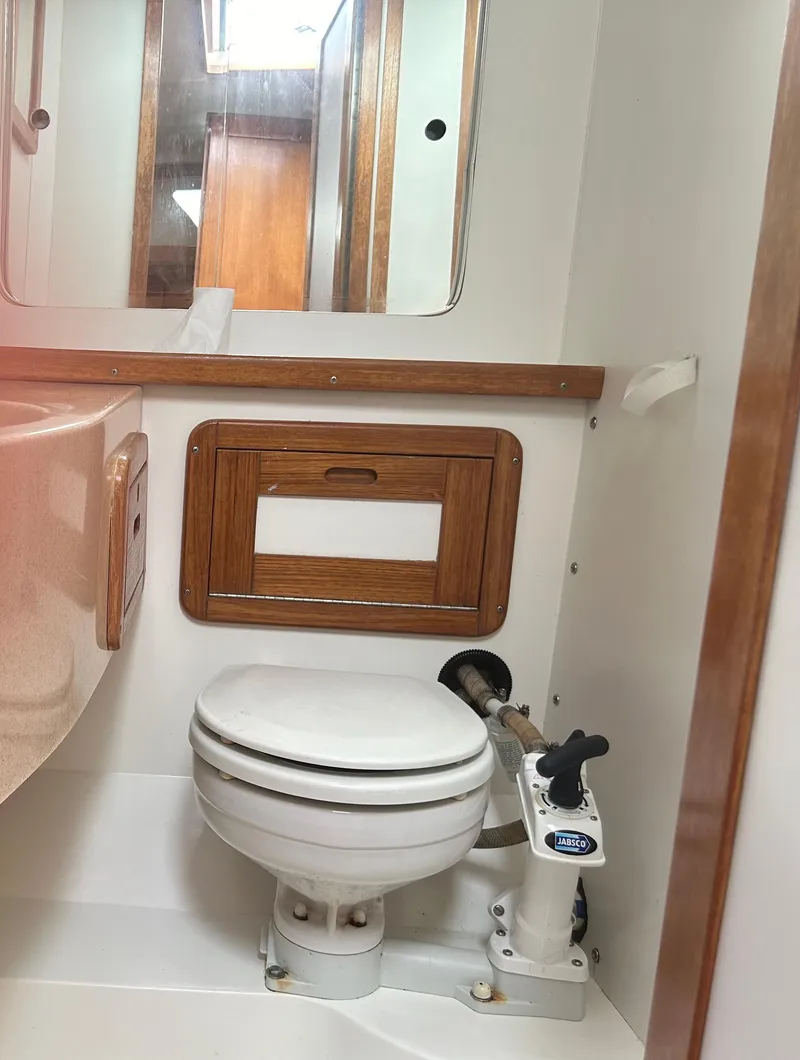 Slide: The Image of 1998 Catalina 42 MkII yacht bathroom with wooden accents and marine toilet. - 11