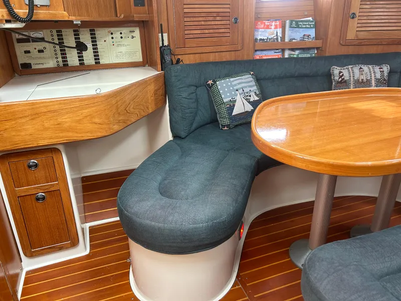 Slide: The Image of Cozy interior of 1998 Catalina 42 MkII sailboat with wooden table and cushioned seating. - 14