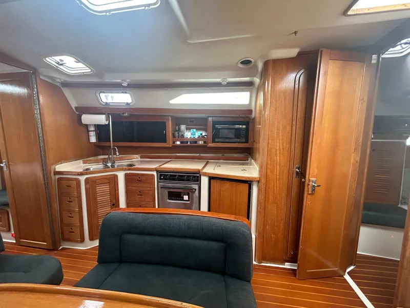 Slide: The Image of Interior of 1998 Catalina 42 MkII sailboat with wood cabinetry and compact kitchen. - 22