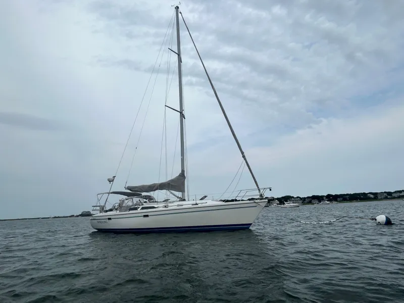 Slide: The Image of 1998 Catalina 42 MkII sailboat on calm water under cloudy sky. - 4