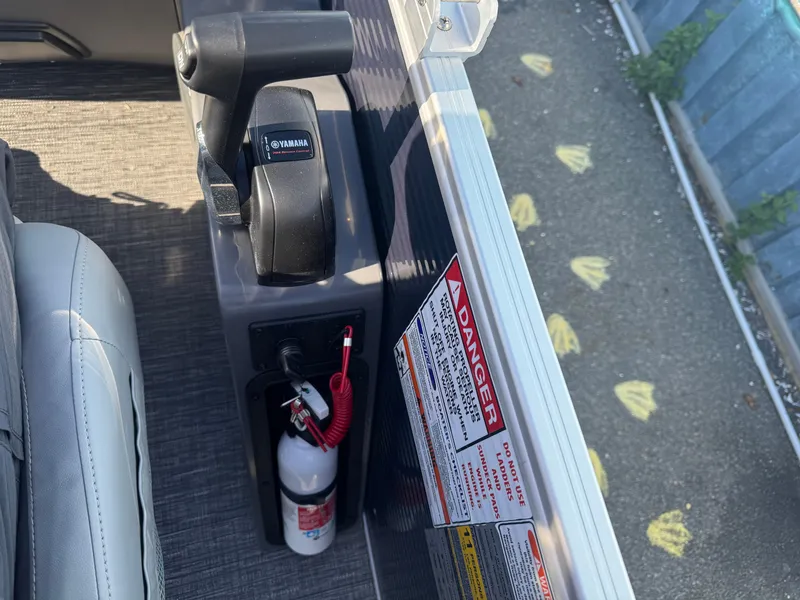 Slide: The Image of Close-up of 2025 Bennington 22 SSRSR boat controls with Yamaha throttle and safety warnings. - 12