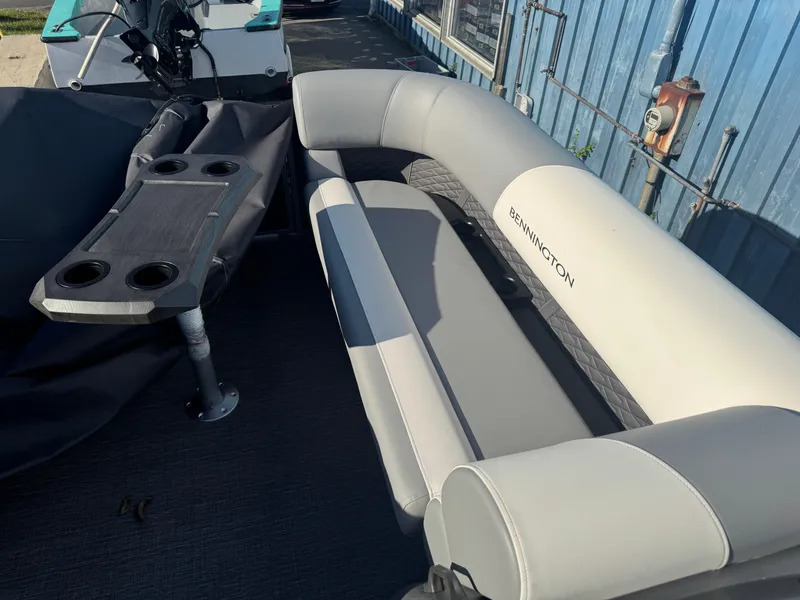 Slide: The Image of 2025 Bennington 22 SSRSR boat interior with gray seating and cupholder table. - 14