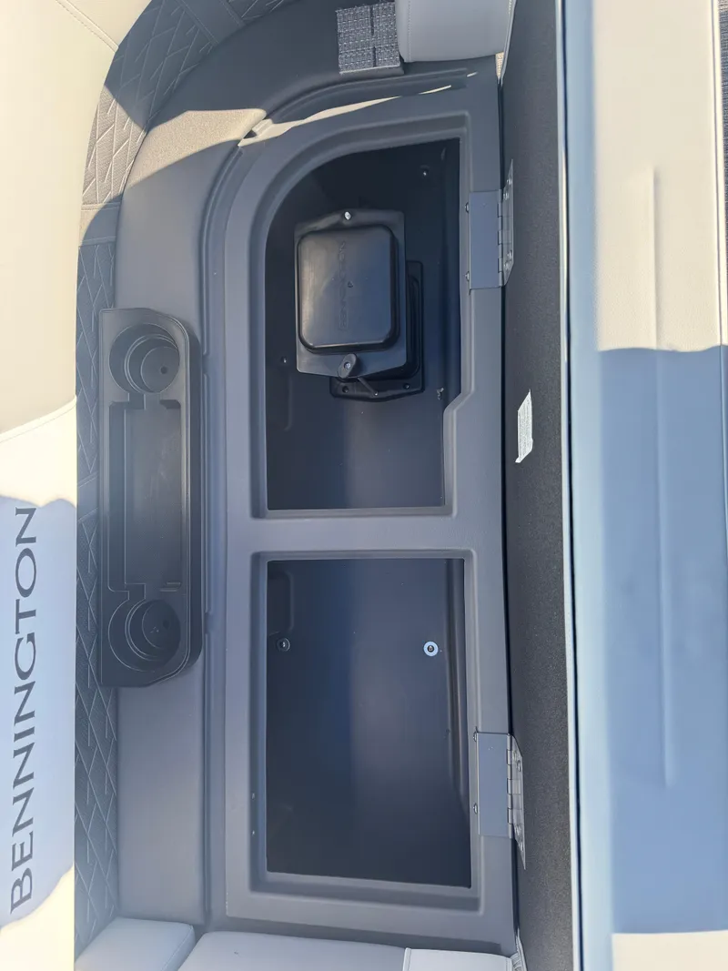Slide: The Image of 2025 Bennington 22 SSRSR boat storage compartment with cup holders and sleek design. - 17