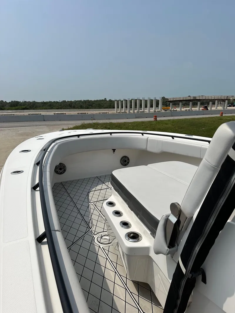 Slide: The Image of 2021 Fountain 34TE boat with spacious deck and seating, docked near a waterfront. - 10