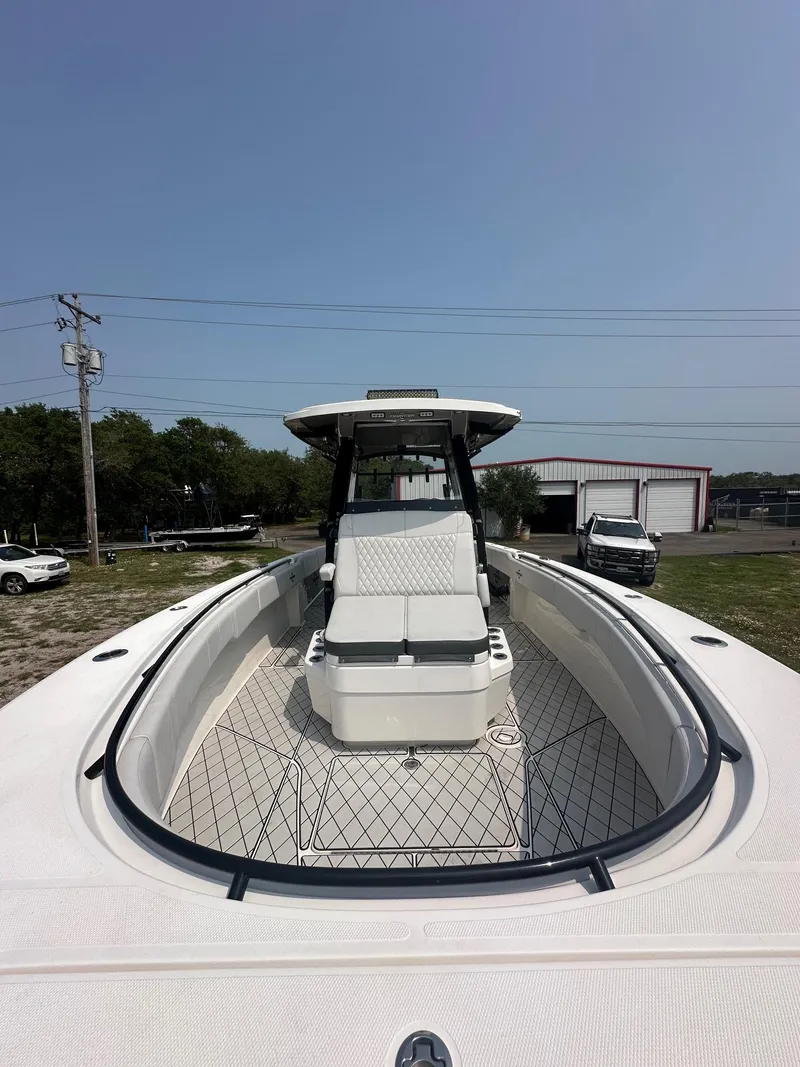 Slide: The Image of 2021 Fountain 34TE boat, front view, docked outdoors under clear sky. - 11