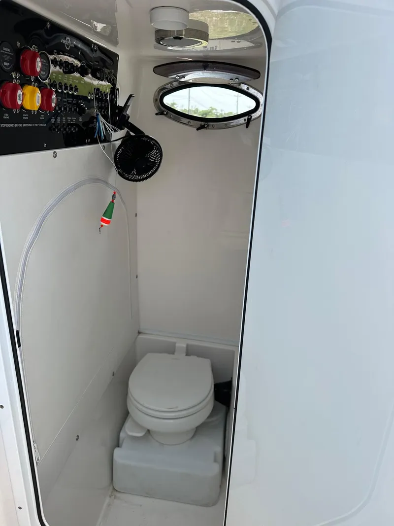 Slide: The Image of 2021 Fountain 34TE boat interior with compact marine toilet and control panel. - 18