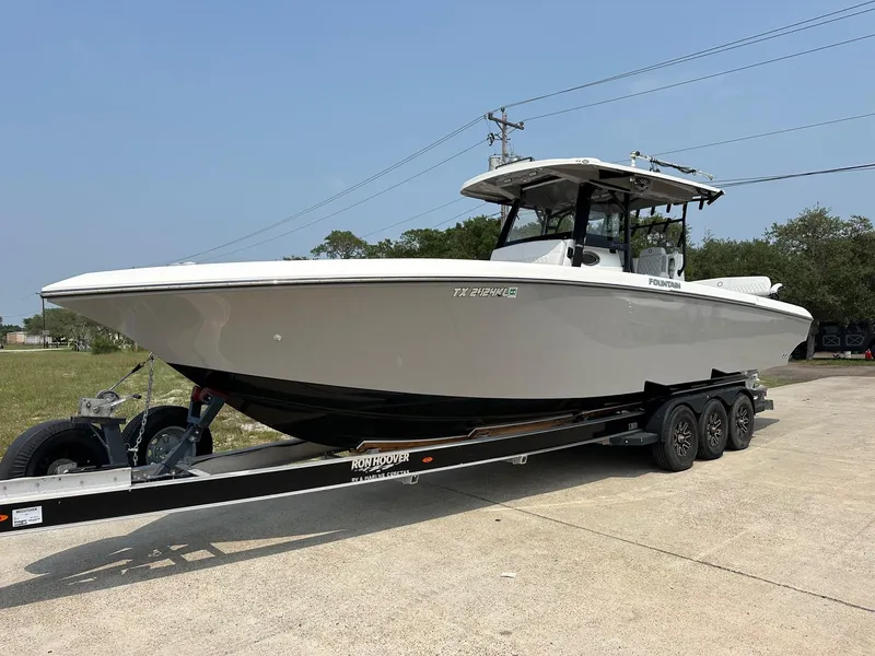 Slide: The Image of 2021 Fountain 34TE boat on trailer, parked outdoors. - 2