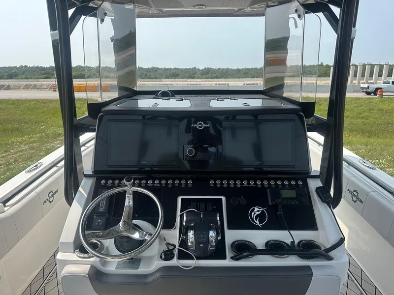 Slide: The Image of 2021 Fountain 34TE boat dashboard with steering wheel and control panels. - 6