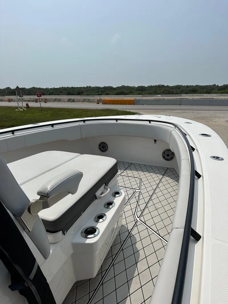 Slide: The Image of 2021 Fountain 34TE boat interior with seating and cup holders, docked outdoors. - 9