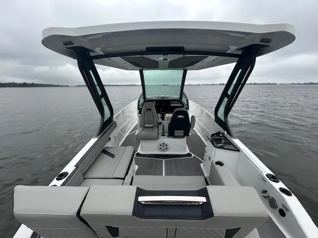 Slide: The Image of 2025 Monterey 27 Elite boat interior with sleek seating and modern design on a calm lake. - 20