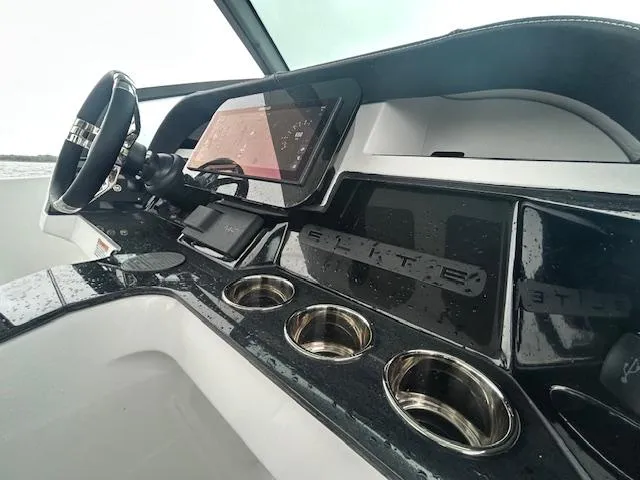 Slide: The Image of 2025 Monterey 27 Elite boat dashboard with modern controls and cup holders. - 7
