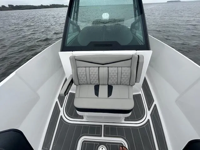 Slide: The Image of 2025 Monterey 27 Elite boat interior with cushioned seating on open water. - 9
