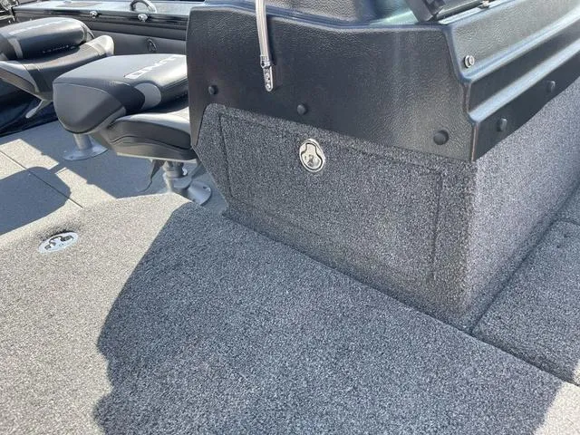 Slide: The Image of 2025 Lund 2075 Pro-V Sport boat interior with carpeted flooring and seating. - 12