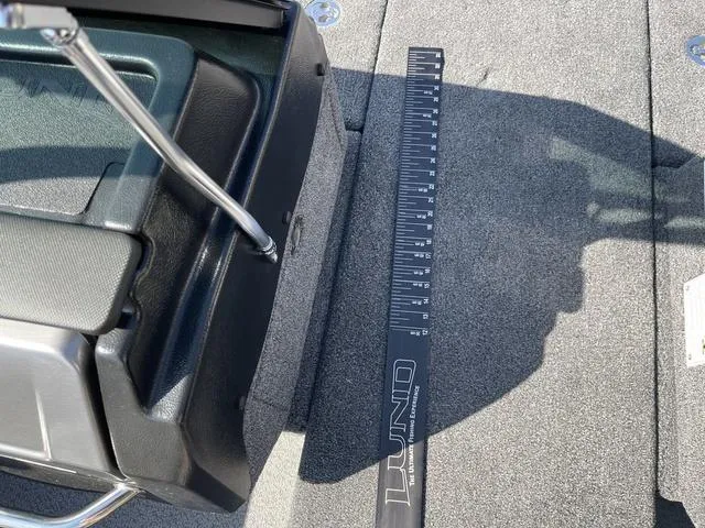 Slide: The Image of 2025 Lund 2075 Pro-V Sport boat interior with measuring ruler on carpeted floor. - 16