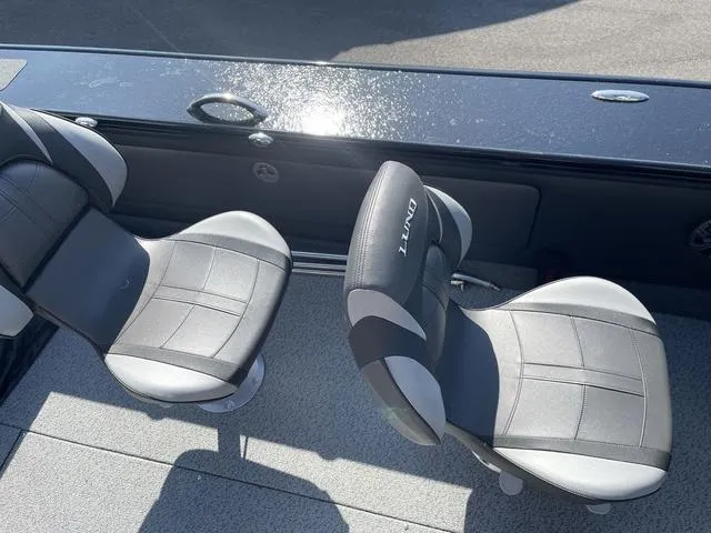 Slide: The Image of 2025 Lund 2075 Pro-V Sport boat seats, black and gray design, sunlit deck. - 21