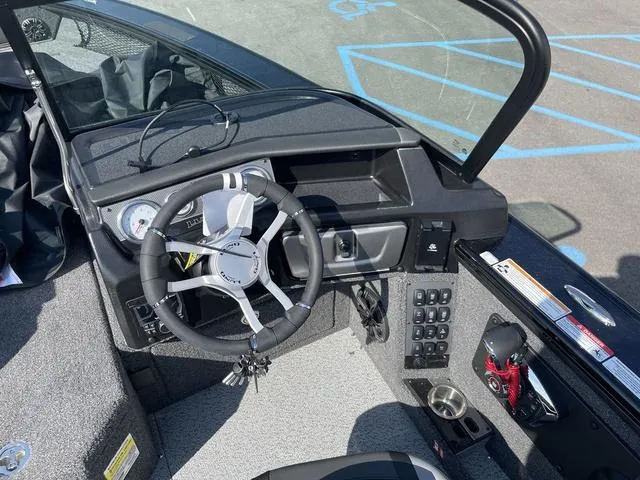 Slide: The Image of 2025 Lund 2075 Pro-V Sport boat cockpit with steering wheel and control panel. - 23