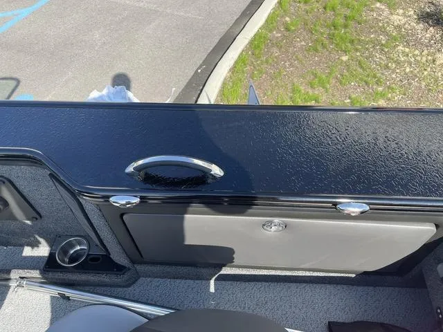 Slide: The Image of 2025 Lund 2075 Pro-V Sport boat interior with sleek black panel and storage compartment. - 30