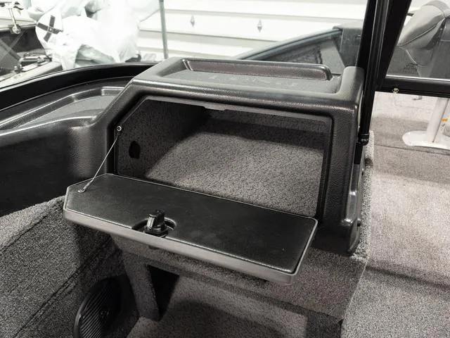 Slide: The Image of 2025 Lund 1875 Impact XS boat interior with storage compartment and carpeted flooring. - 12