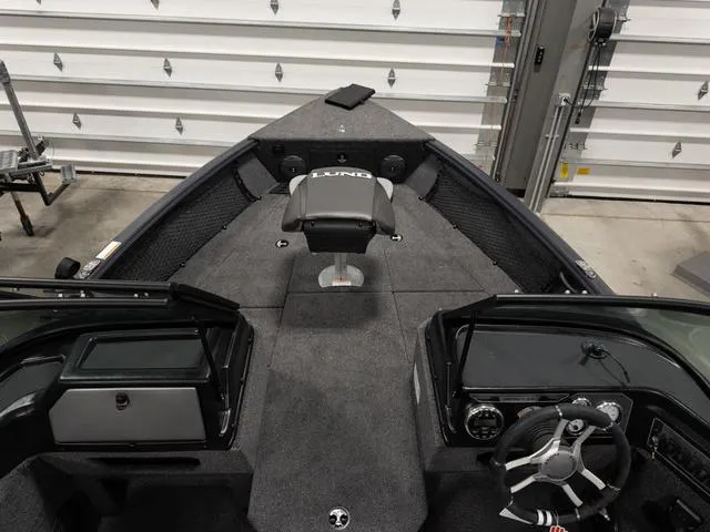 Slide: The Image of 2025 Lund 1875 Impact XS boat interior with steering wheel and seating. - 13