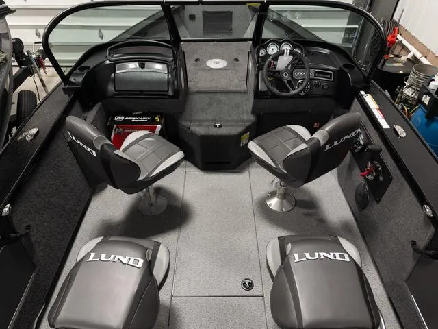 Slide: The Image of 2025 Lund 2075 Fisherman Sport boat interior with four seats and dashboard. - 10