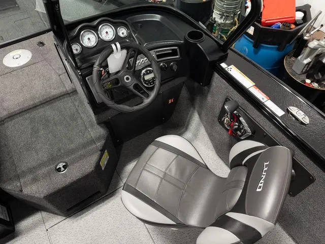 Slide: The Image of 2025 Lund 2075 Fisherman Sport boat interior with steering wheel and seat. - 13