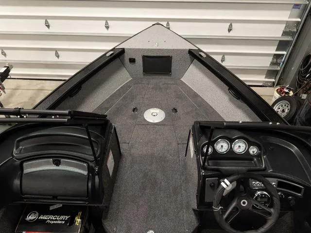 Slide: The Image of 2025 Lund 2075 Fisherman Sport boat interior with steering wheel and dashboard gauges. - 20