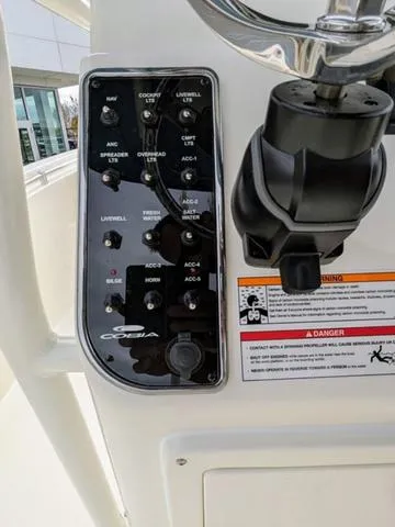 Slide: The Image of 2025 Cobia 220 CC boat console with steering wheel and electronic displays. - 21